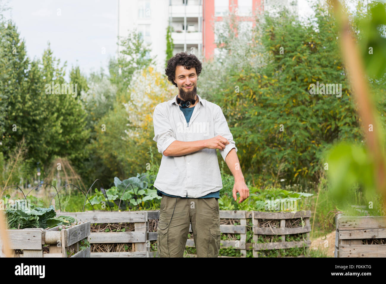 Giovane uomo in piedi in un giardino urbano Foto Stock