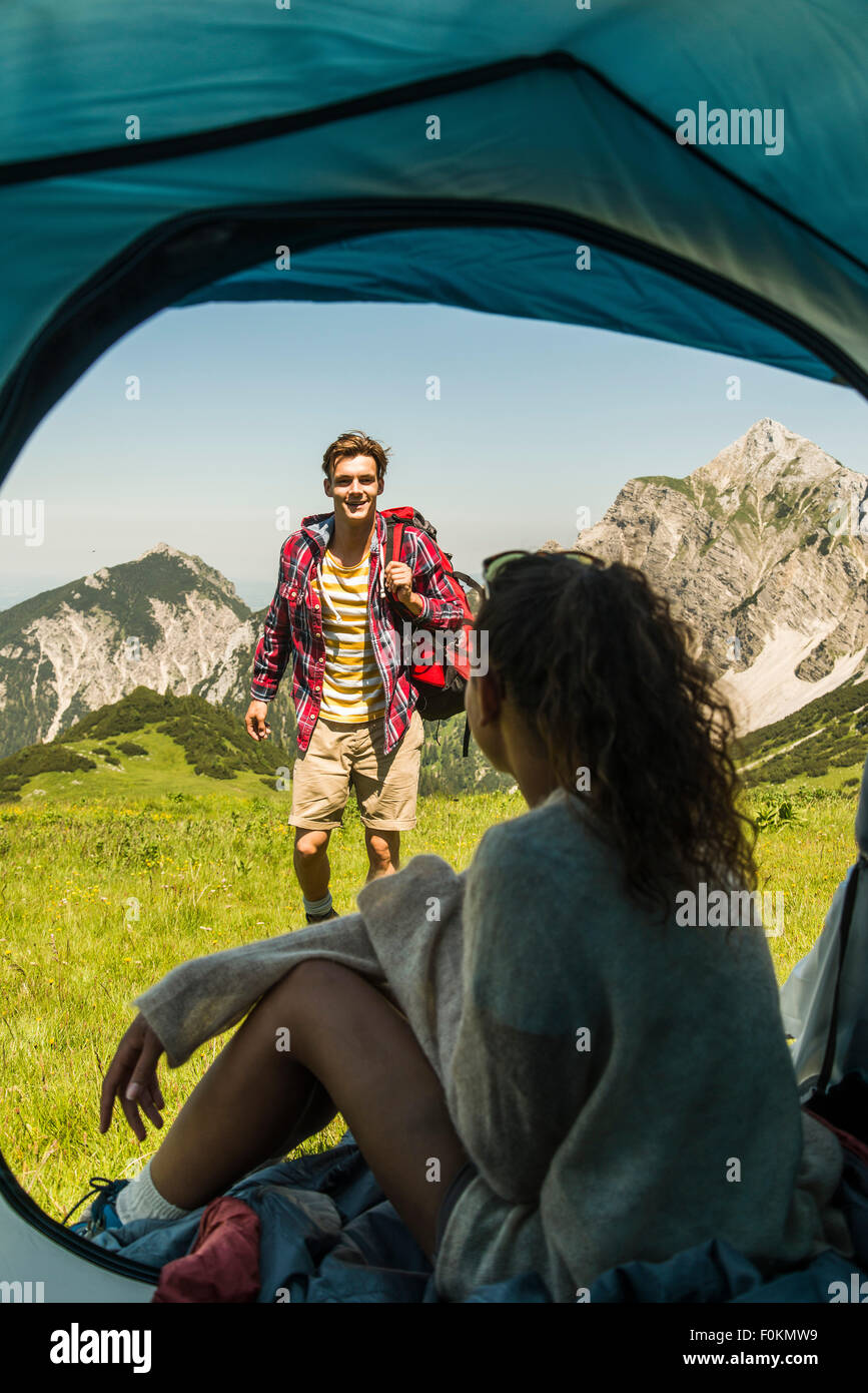 Austria, Tirolo, Tannheimer Tal, coppia giovane camping sul prato alpino Foto Stock