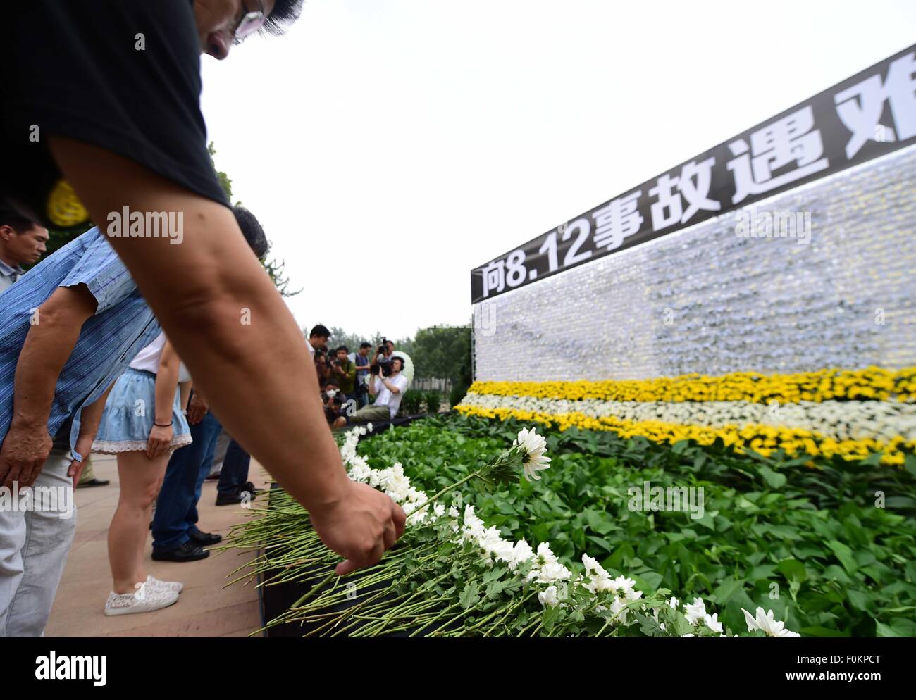 Tianjin, Cina. 18 Agosto, 2015. Una cerimonia di lutto è mantenuto per le vittime del massiccio di esplosioni di magazzino, in corrispondenza di una strada parco in Binhai Nuova Area di Tianjin, Cina del nord, e il agosto 18, 2015. Il tributo di morte pagato la scorsa settimana le massicce di blasti in Tianjin è salito a 114. Credito: Yue Yuewei/Xinhua/Alamy Live News Foto Stock