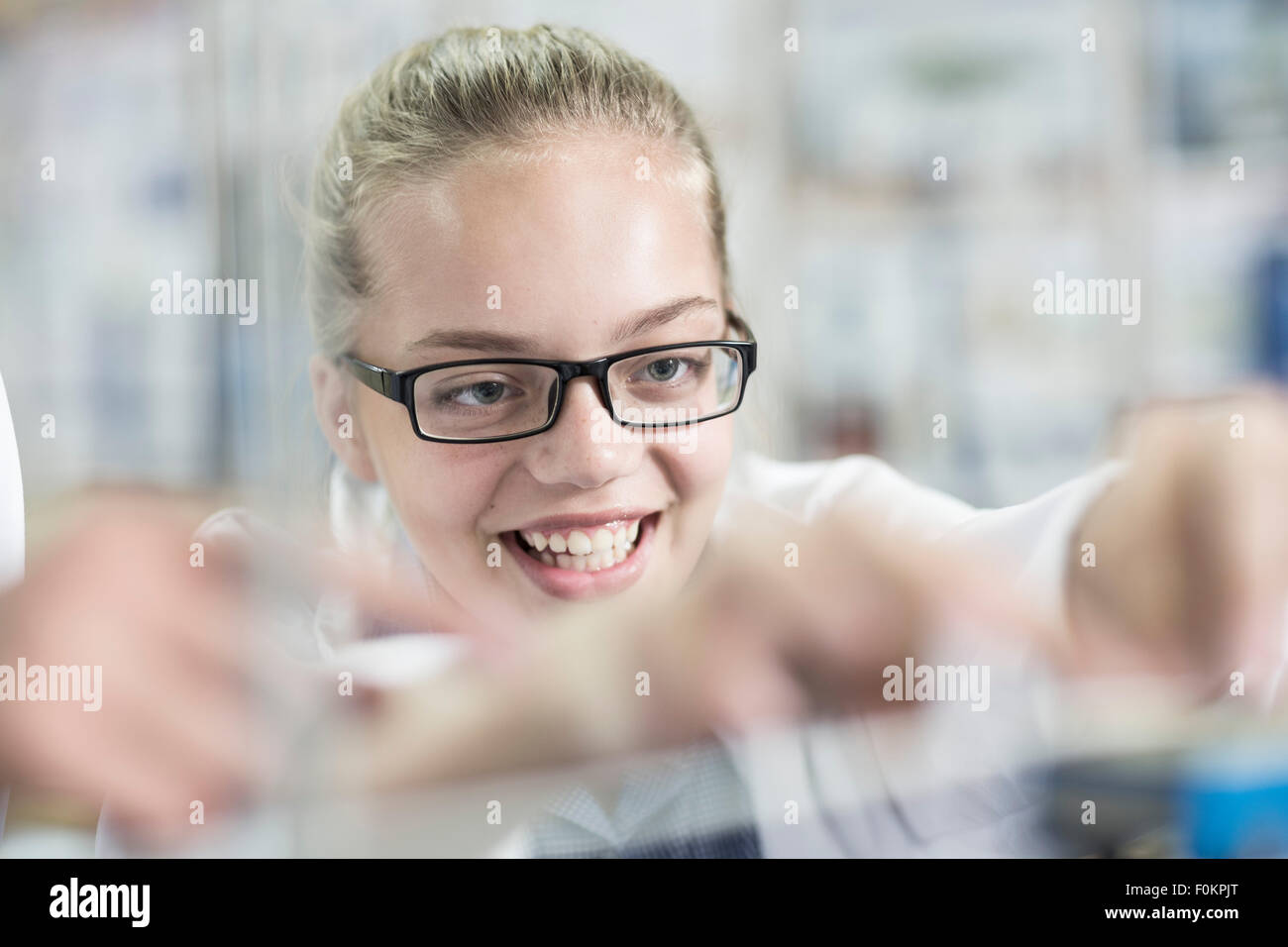 La scolaretta sorridente in classe fisica Foto Stock