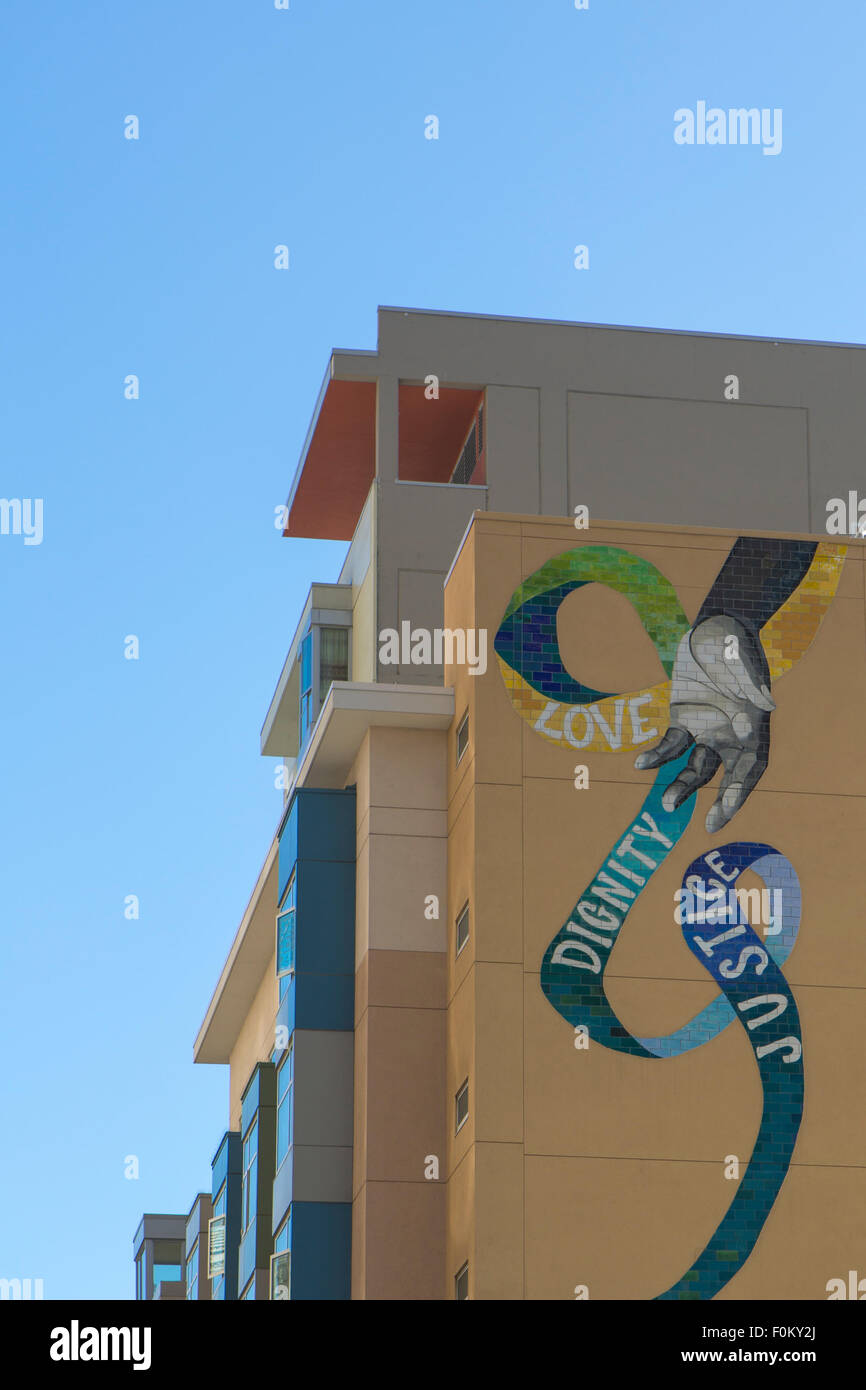 L'amore, la dignità, la giustizia, la pittura a lato di un moderno palazzo residenziale in San Francisco 2012 Foto Stock