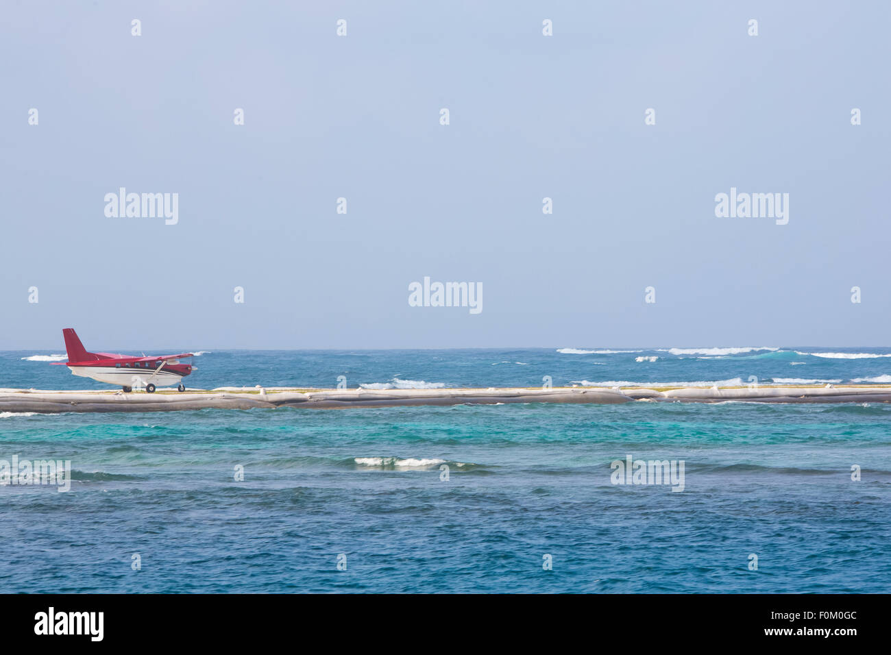 Piccolo rosso piano attorno al decollo su pista artificiale con l'oceano tutti intorno in isole San Blas, Panama 2014. Foto Stock