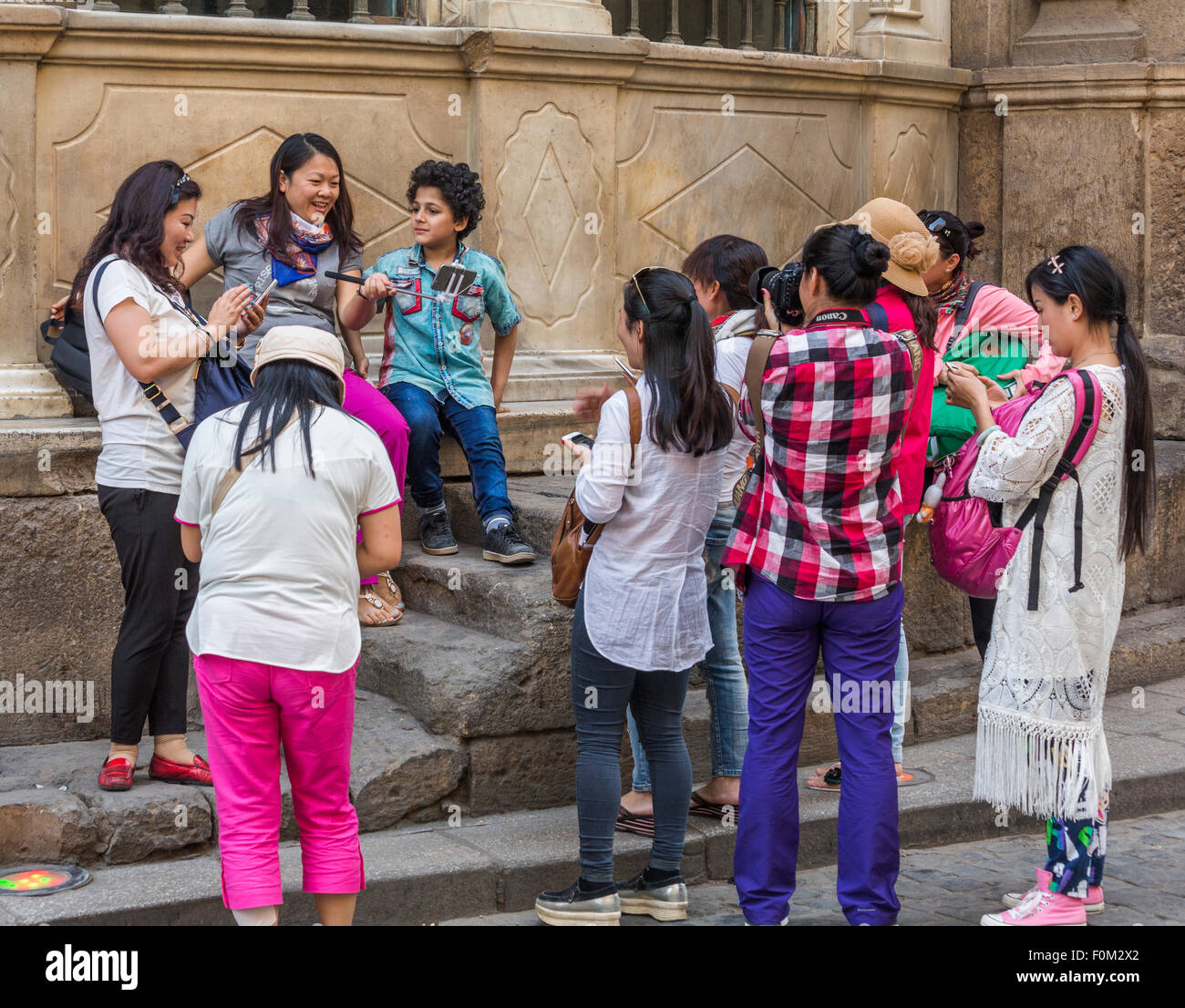 I turisti cinesi tenendo fotografia del ragazzo egiziano al Cairo, Egitto Foto Stock