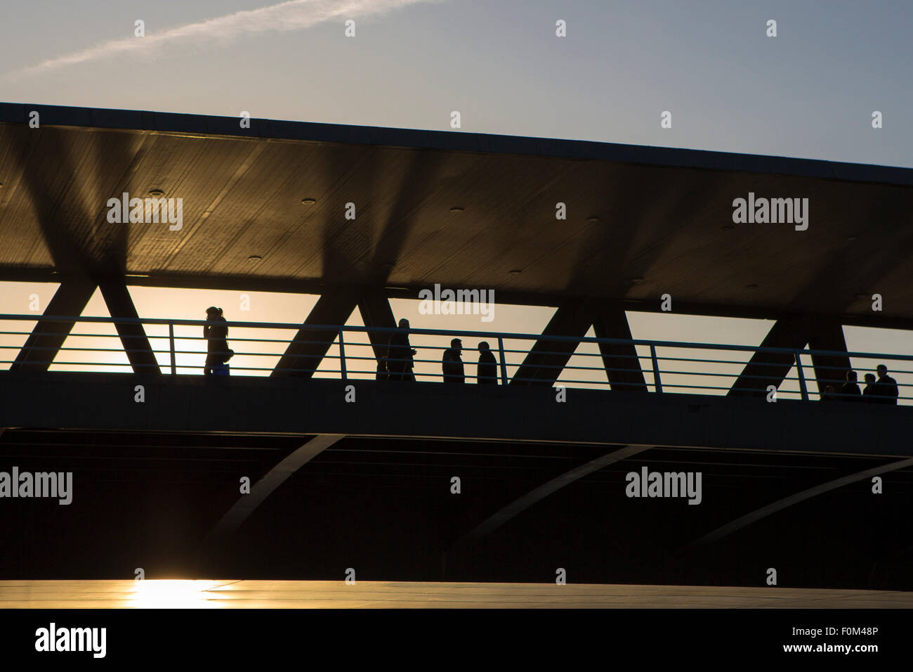 La gente sul ponte durante il tramonto a Bilbao Foto Stock