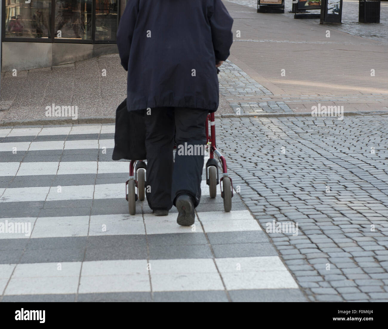 Donna anziana con attraversamento Walker Street a strisce pedonali in città Foto Stock