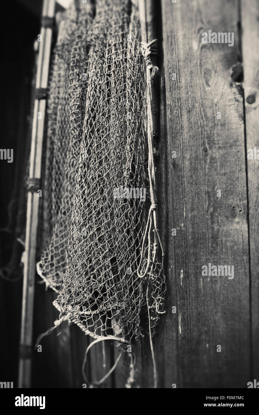 Natura morta con la vecchia rete da pesca appesa sulla parete in legno Foto Stock