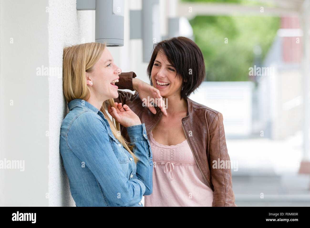 Due amiche ridere insieme e parlare Foto Stock