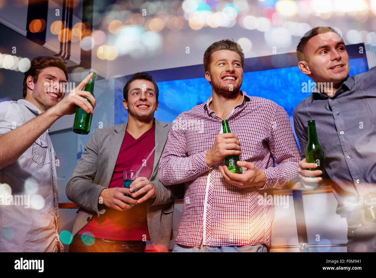 Gruppo di amici maschi con la birra in discoteca Foto Stock