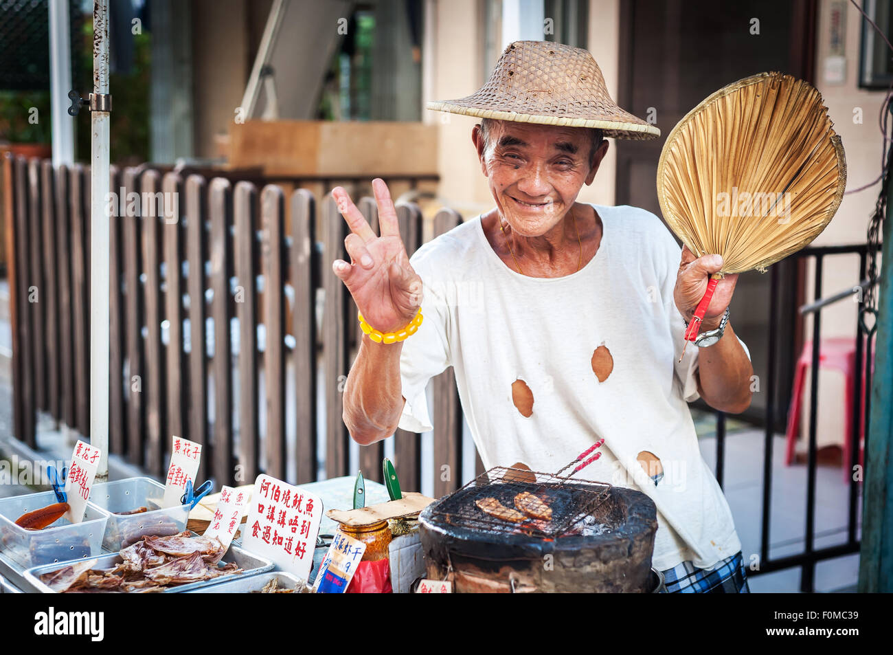 Hawker vendita calamari alla griglia a Tai O villaggio, l'Isola di Lantau, Hong Kong Foto Stock