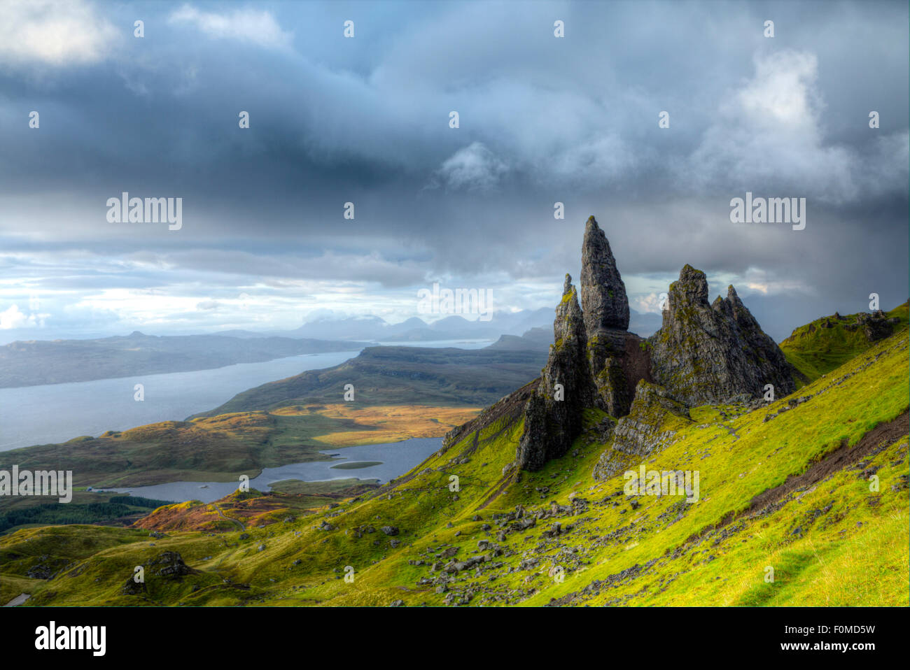 Il vecchio uomo di Storr rocce di Trotternish Ridge nella regione a nord di Isola di Skye che mostra il Loch Leathan lago, il suono interno stretto e l'isola di Raasay Foto Stock