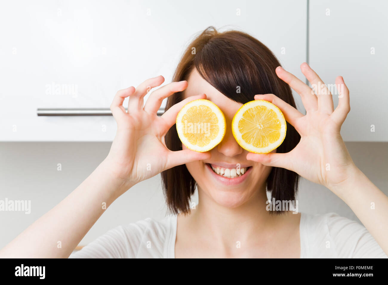 Giovane donna holding cedri davanti agli occhi Foto Stock