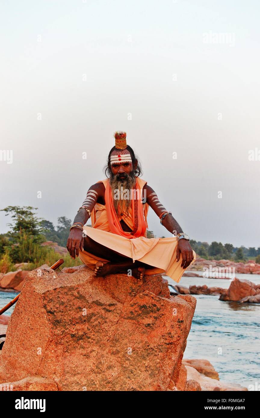 Sadhu indù, o santo uomo seduto su una roccia nel fiume Betwa, Orchha, Madhya Pradesh, India Foto Stock