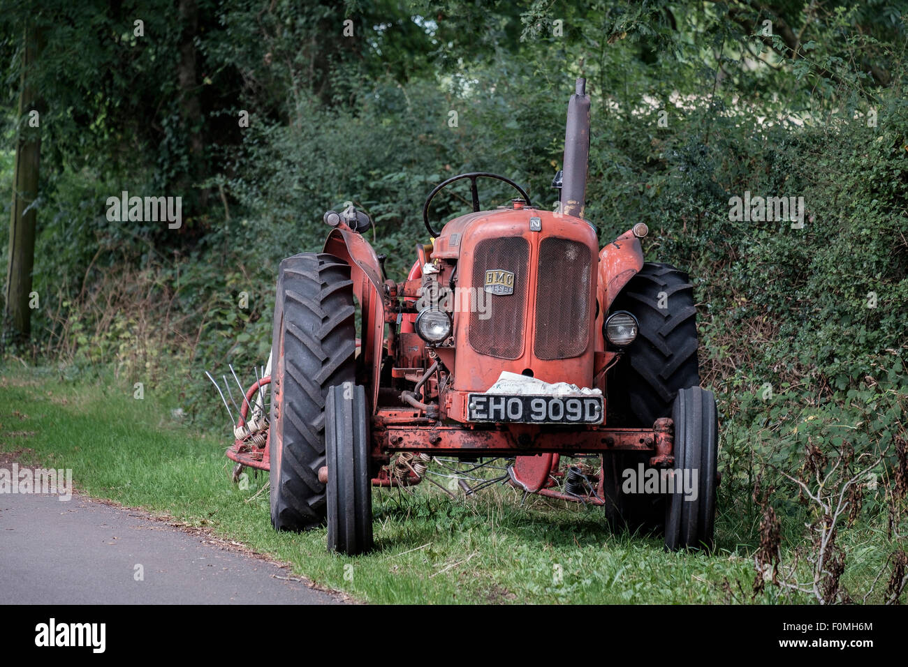 Un vintage red BMC Nuffield /42 trattore parcheggiato in una corsia nella New Forest National Park, Hampshire, Inghilterra, Regno Unito. Foto Stock