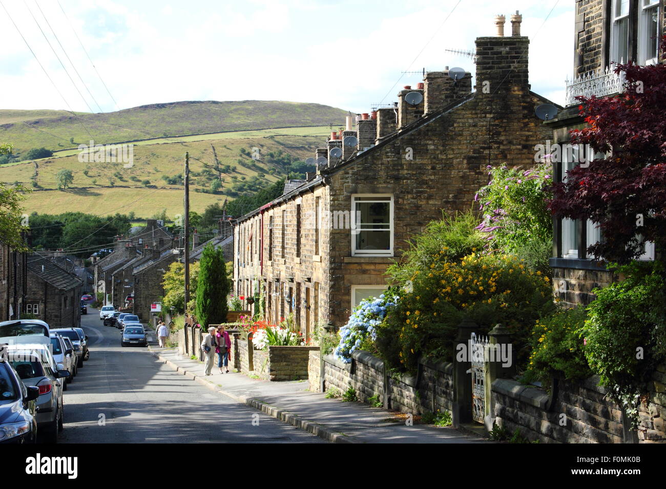 Una vista di case terrazza su strada Kinder in Hayfield guardando verso le colline del Parco Nazionale di Peak District, England Regno Unito Foto Stock