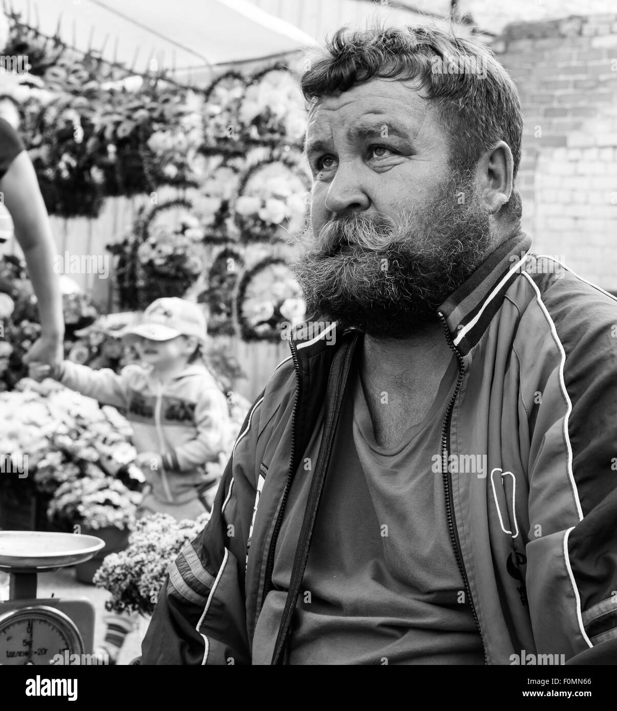 Forte ingombranti cercando l'uomo con grandi baffi e riccio incolto barba alza lo sguardo verso il cielo Foto Stock