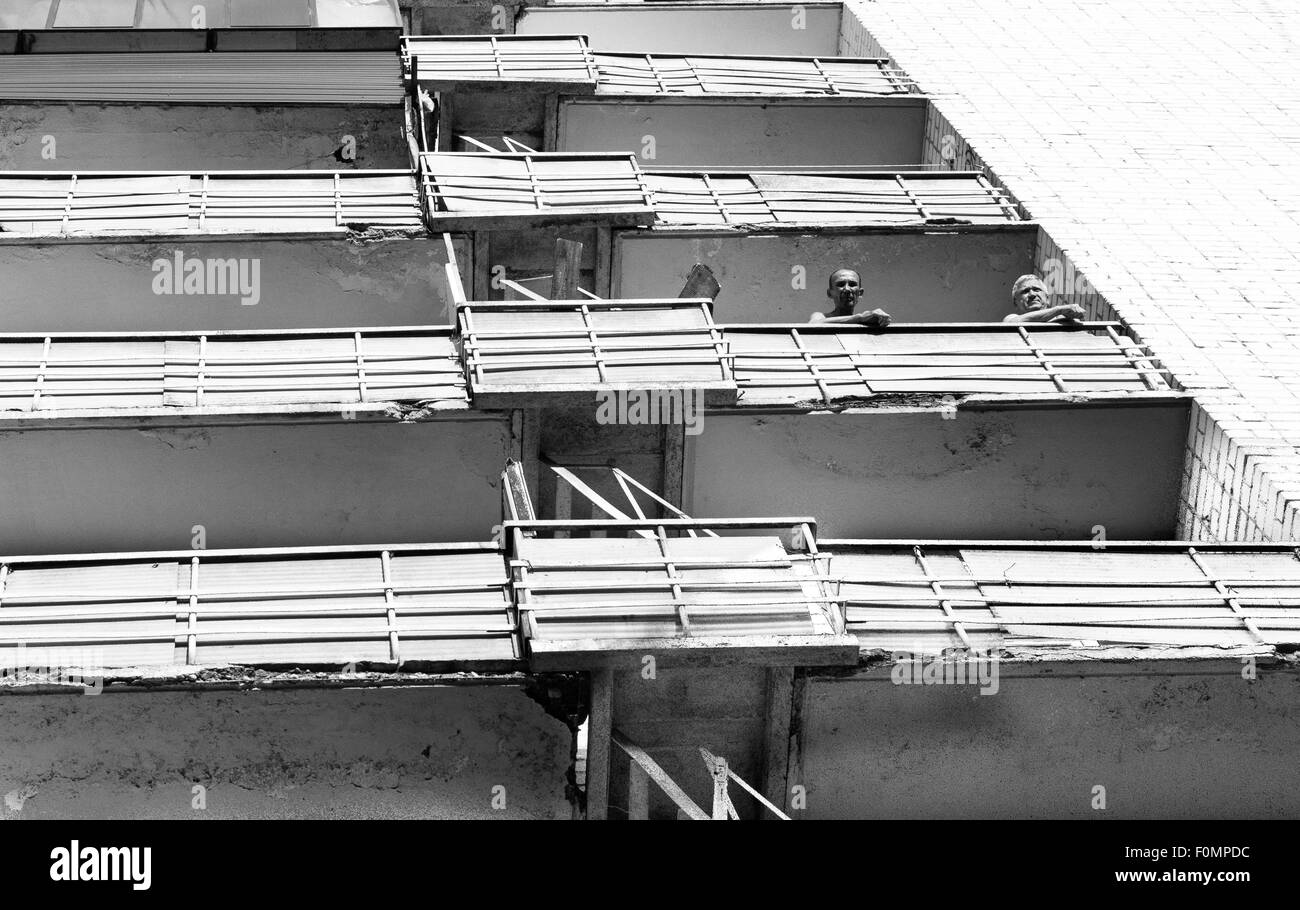 Due pensionati anziani stare fuori dal vecchio alloggiamento balcone Foto Stock
