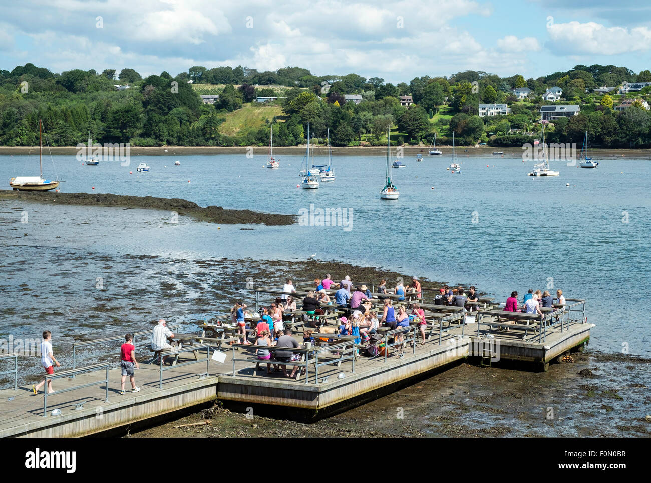 La gente di cenare sulla pontoon appartenenti al Pandora Inn at Restronguet creek vicino a Falmouth in Cornovaglia, Regno Unito Foto Stock