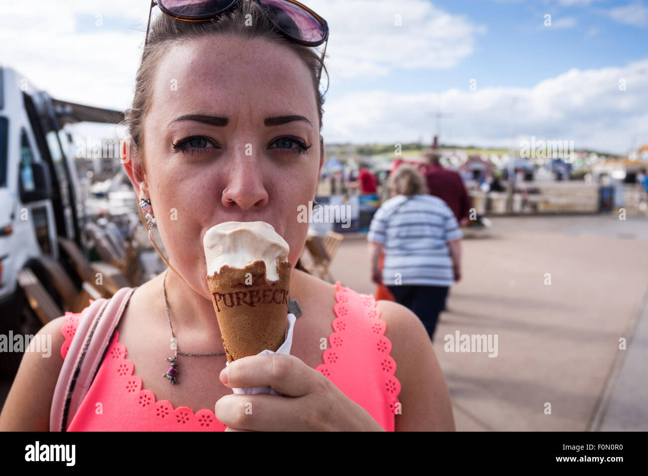 Giovane donna di mangiare un gelato al mare Foto Stock