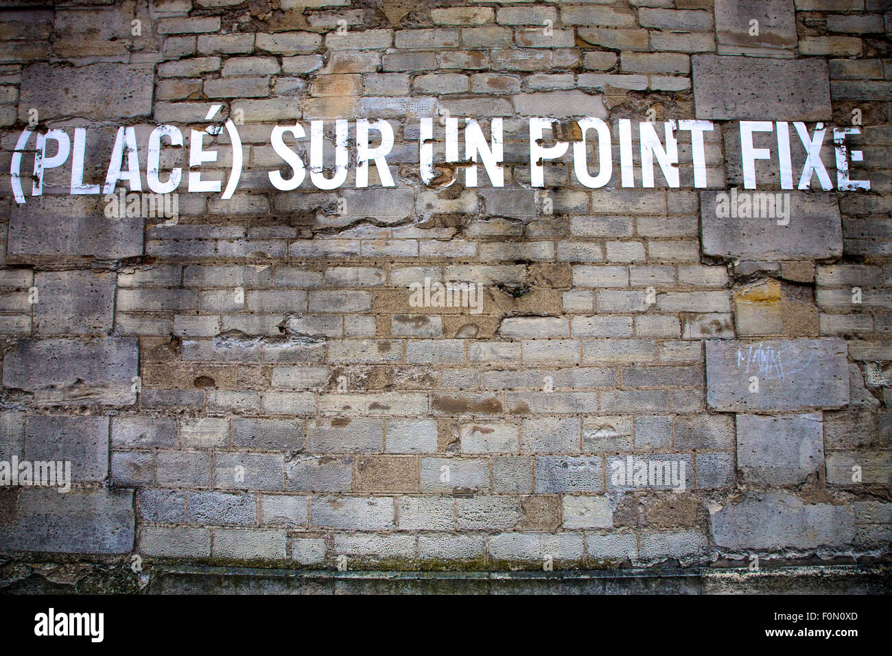 Messaggio su una parete a Parigi dicendo: collocato su un punto fisso Foto Stock