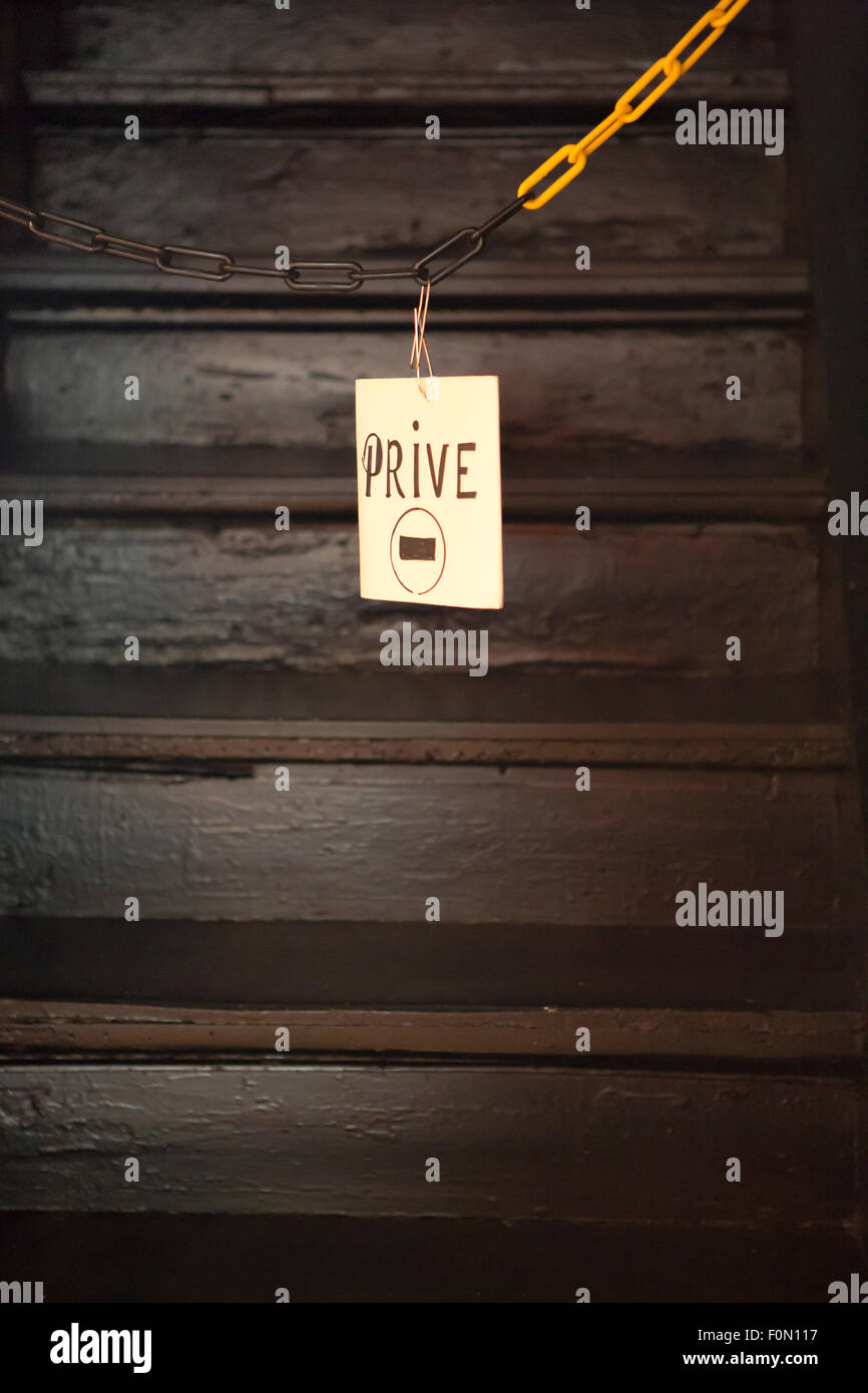 Battere nessun segno sconfinamenti appeso alla catena con scale in background Foto Stock