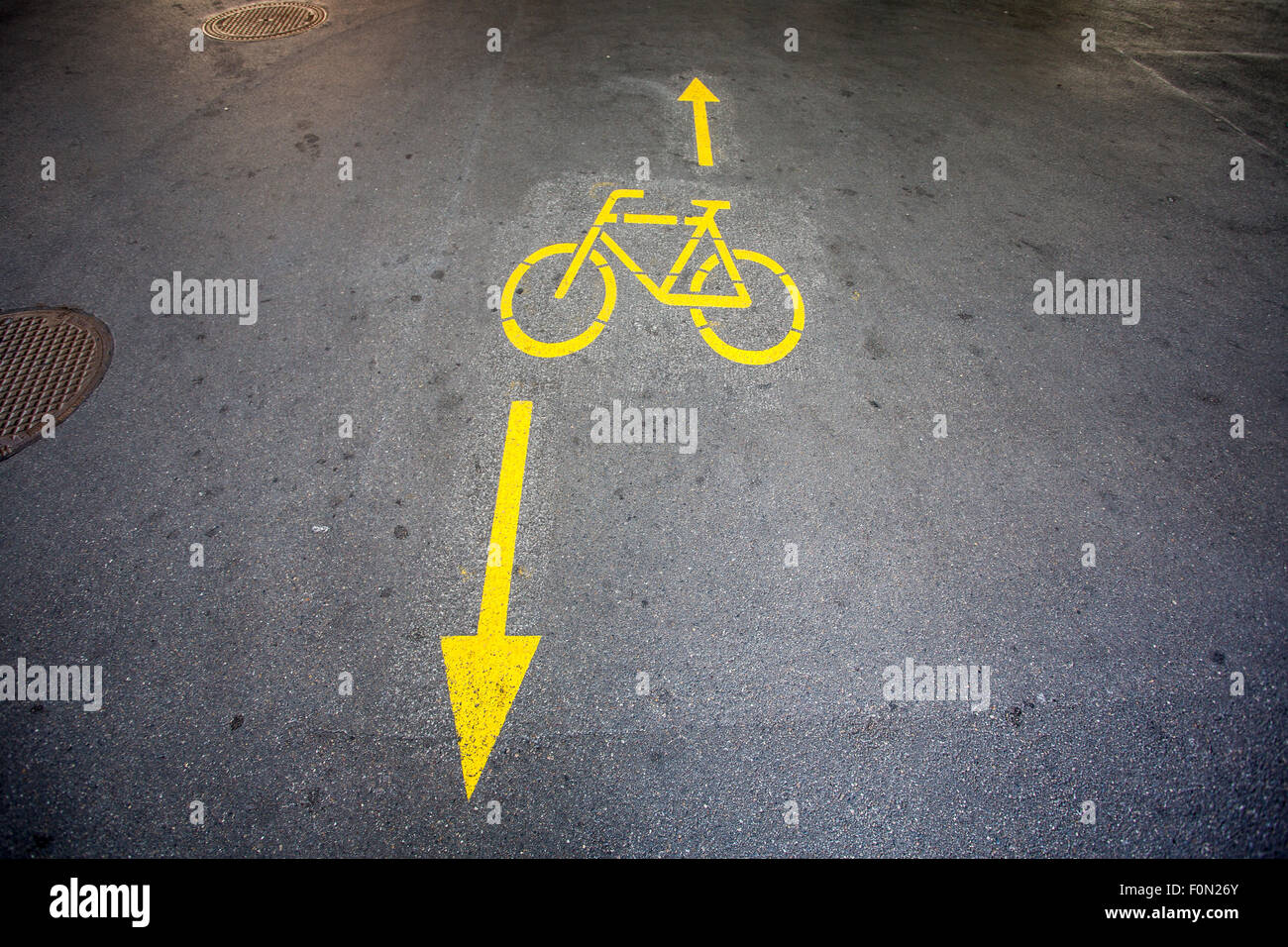 Le frecce gialle e segno di bicicletta percorso su strada presso l
