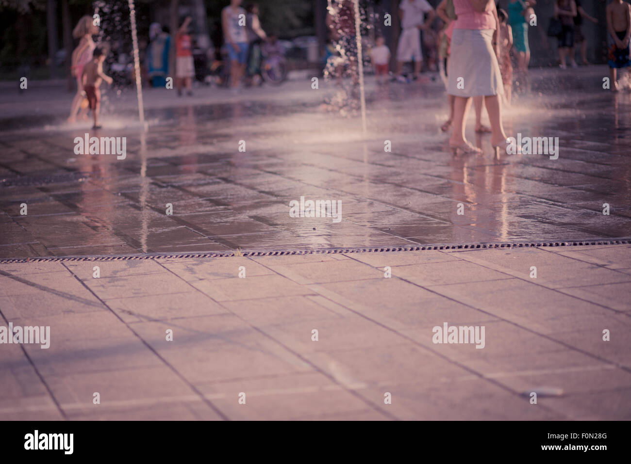 Irriconoscibile bambini e persone a giocare e camminare nella soleggiata Place Flagey a Bruxelles. 2014 Foto Stock