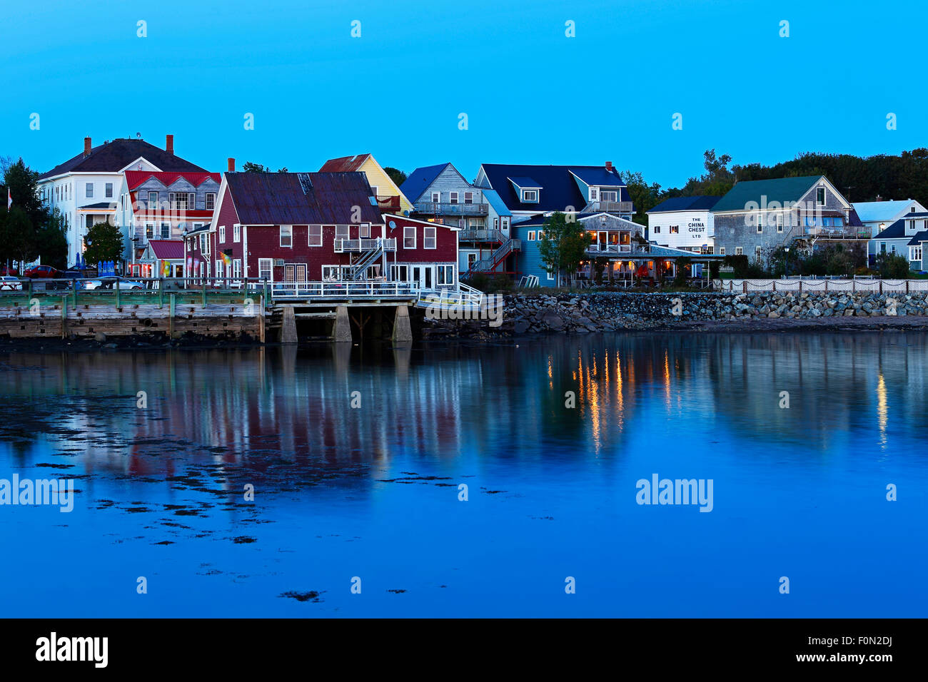 Twilight riflessioni degli edifici e le luci sul lungomare a Saint Andrews, New Brunswick, Canada. Foto Stock