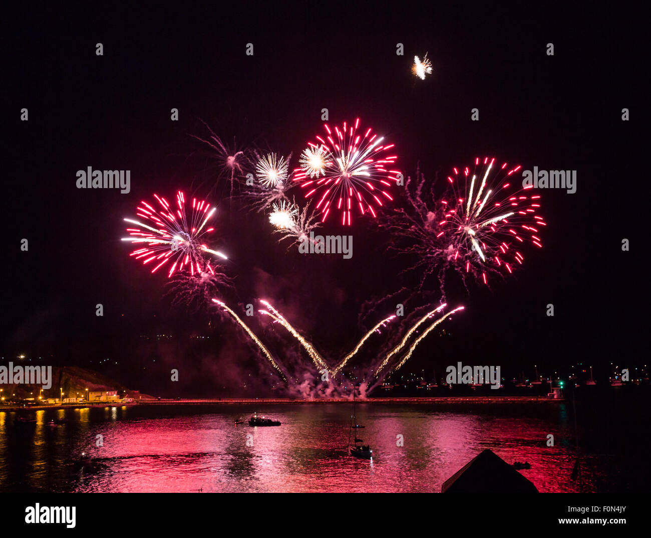 Plymouth, UK. 18 Agosto, 2015. L'inizio del Phoenix fuochi d'artificio entrata in British fuochi d'artificio Championships 2015 a Plymouth Regno Unito. I gusci di rosso riflettono nell'acqua di Plymouth sound come il display inizia a. Credito: Anna Stevenson/Alamy Live News Foto Stock
