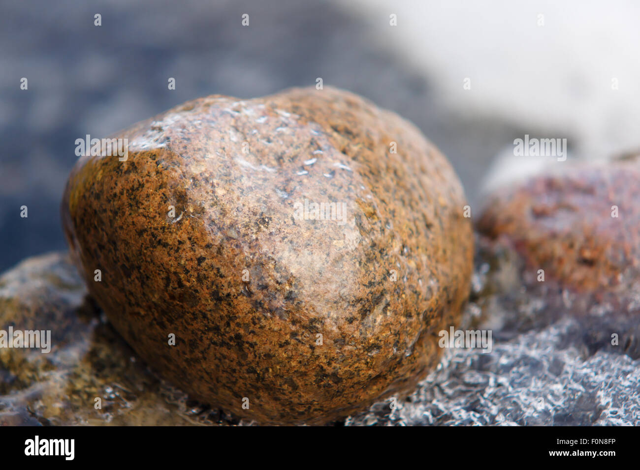 La grande pietra in un coperchio di ghiaccio si aspetta la molla Foto Stock