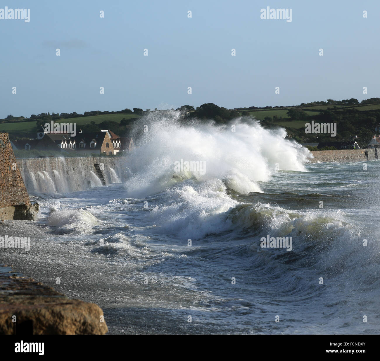 Onde che si infrangono contro il muro a Vazon Bay, Guernsey in seguito ad una tempesta di mare. Foto Stock