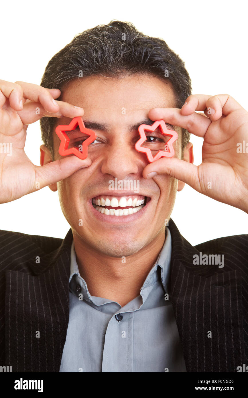 Uomo Felice Tiene due stelle di fronte ai suoi occhi Foto Stock