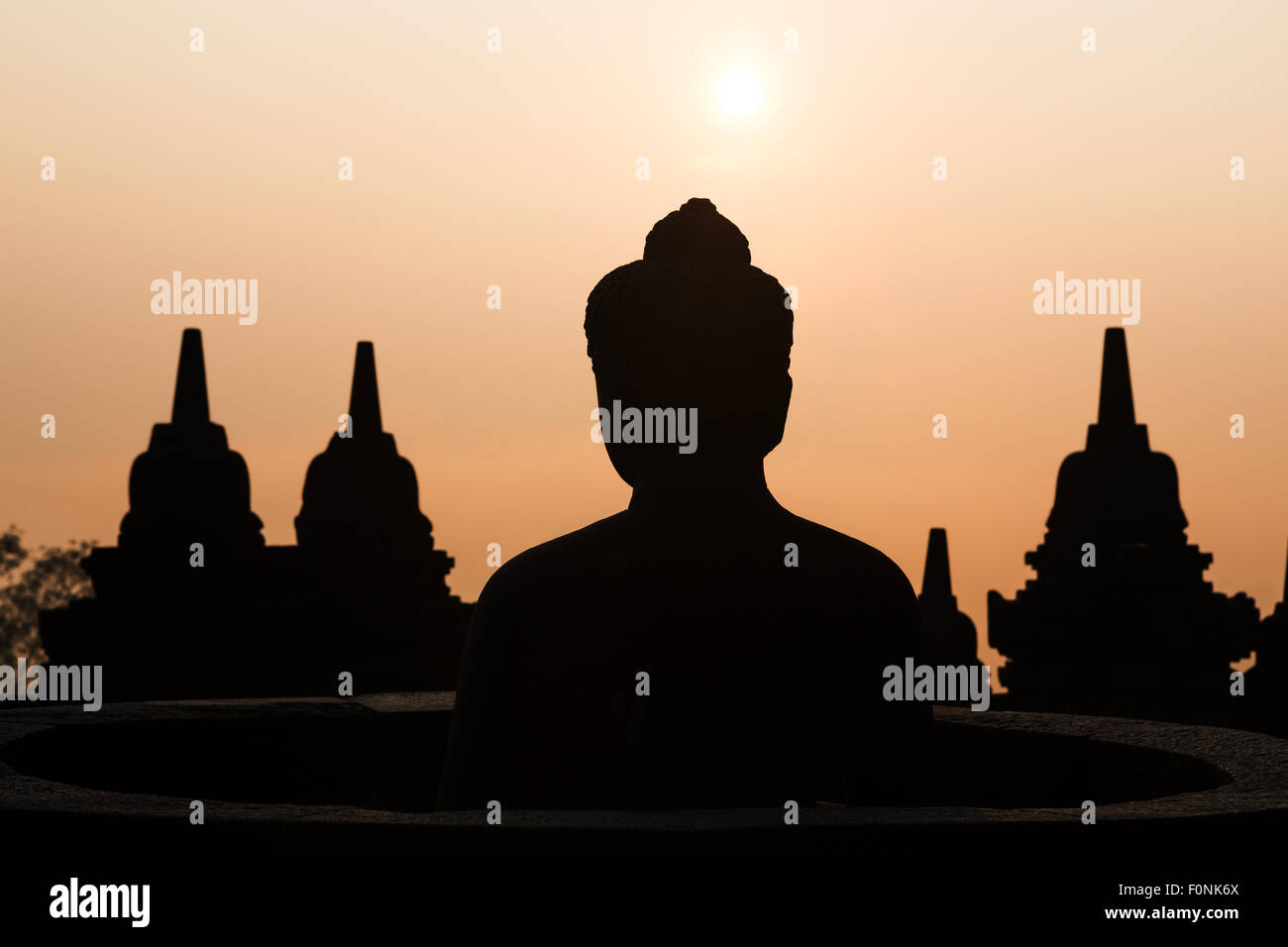 Sagome di una statua del Buddha presso il sito patrimonio mondiale dell'Unesco il tempio di Borobudur all'alba sull isola di Giava, in Indonesia, in Asia. Foto Stock