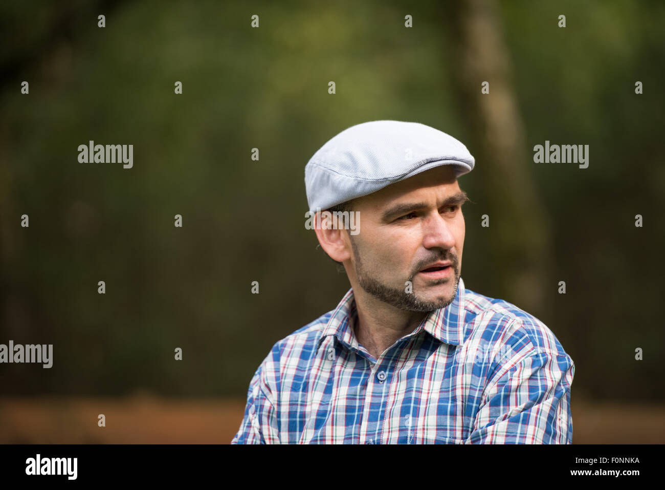 La mezza età uomo barbuto che indossa di basso profilo e cappuccio guardando al lato Foto Stock