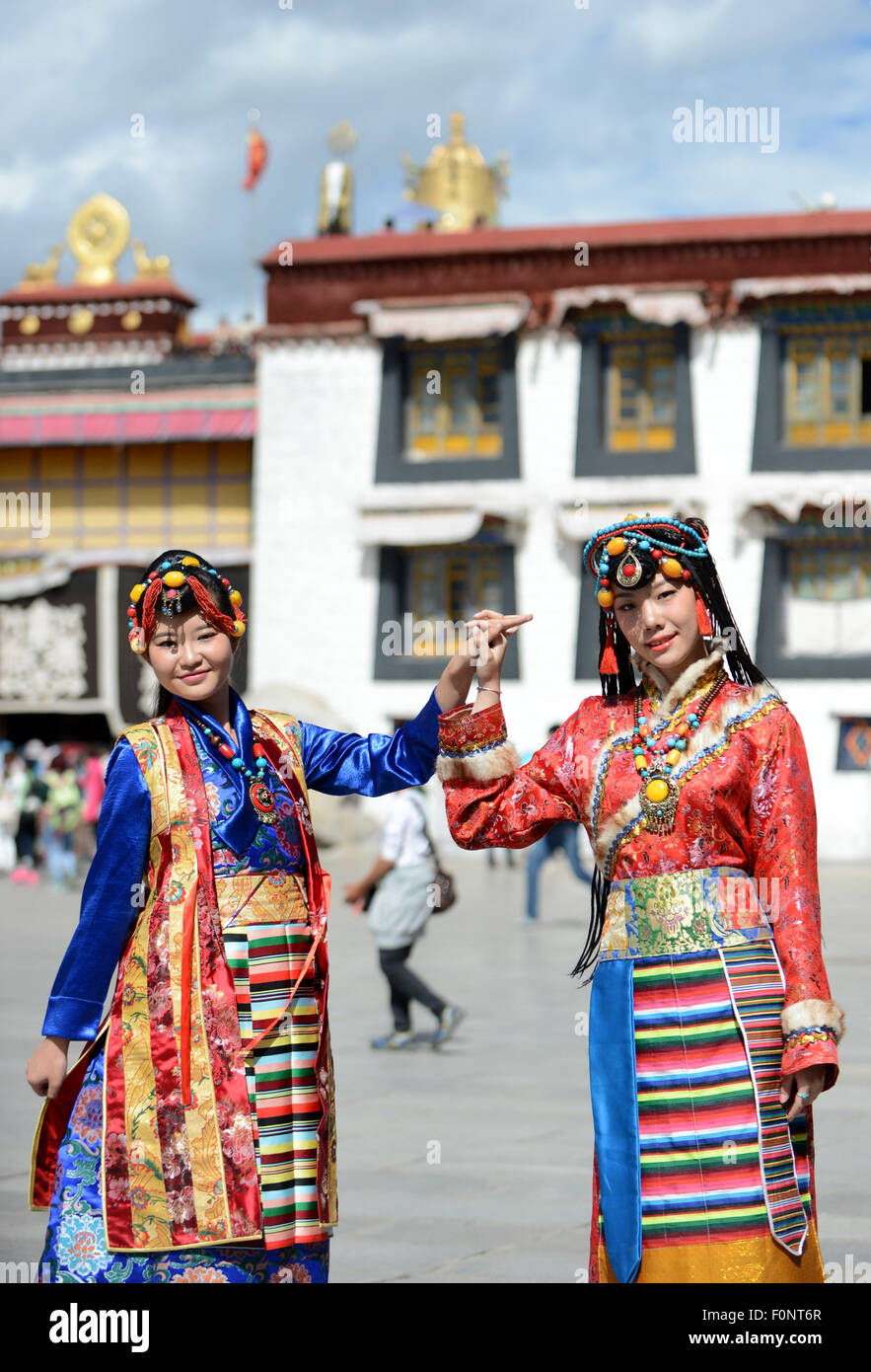 Lhasa, la Cina della regione autonoma del Tibet. 19 Ago, 2015. Due turisti comportano per le foto davanti il tempio del Jokhang a Lhasa, a sud-ovest della Cina di regione autonoma del Tibet, 19 Agosto, 2015. Con le migliori condizioni meteorologiche in un anno, il Tibet è entrato nel picco stagionale del turismo. Credito: Chogo/Xinhua/Alamy Live News Foto Stock