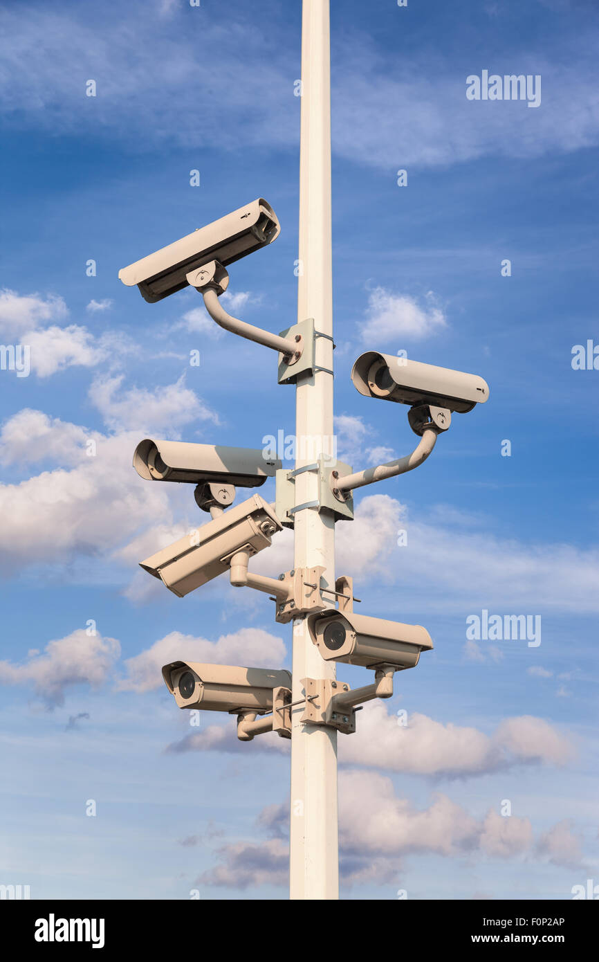 Pole con diverse telecamere di sicurezza un cielo blu. Foto Stock