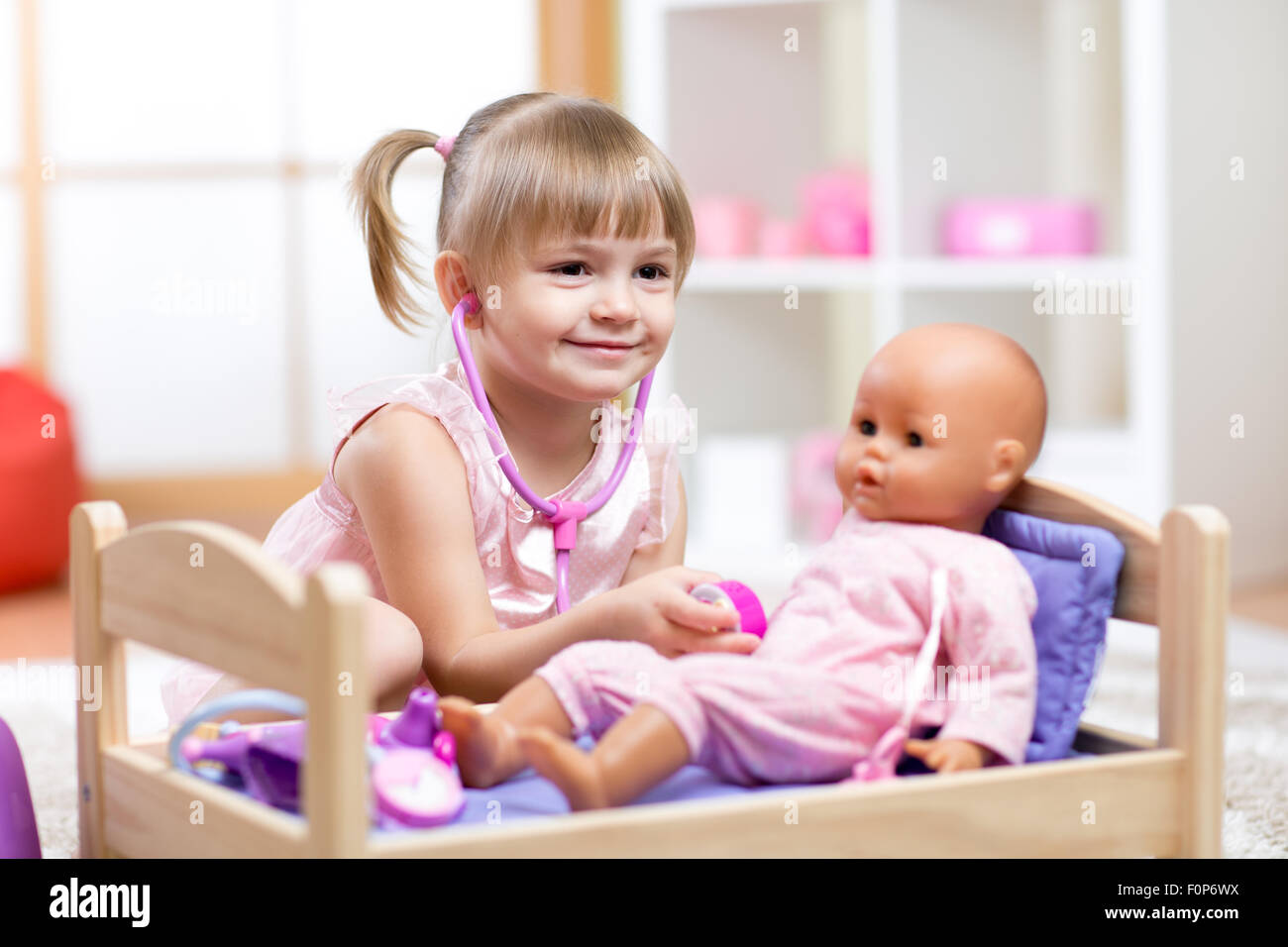 Bambino che gioca medico con una bambola giocattolo Foto Stock