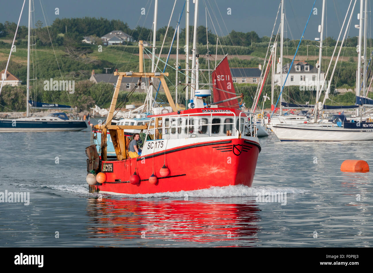 Una barca da pesca ritorna al suo posto barca a Hugh porto cittadino in una gloriosa luce della sera. Foto Stock