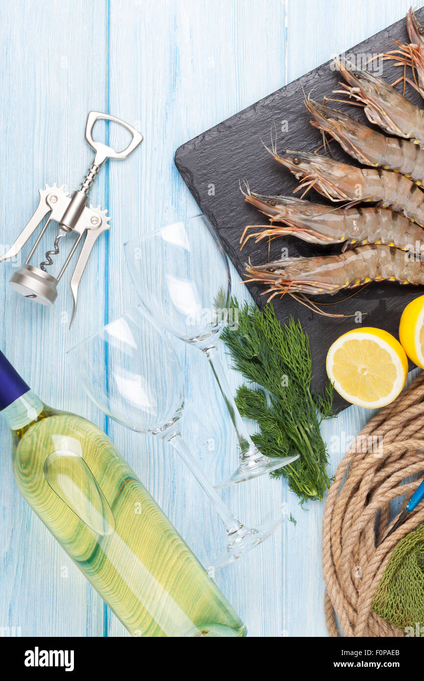 Crudo fresco gamberoni, spezie e vino bianco su tavola di legno Foto Stock