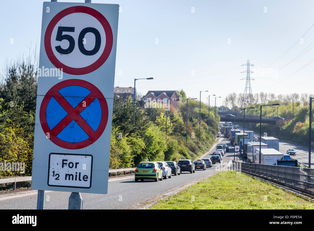 50 mph segnale di limite di velocità e una sosta cartello stradale con la congestione del traffico sulla A454, Black Country Route, Bentley, West Midlands, England, Regno Unito Foto Stock