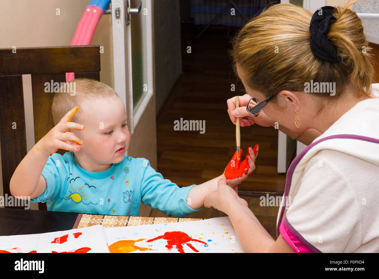 La madre e il bambino disegna le vernici luminose Foto Stock