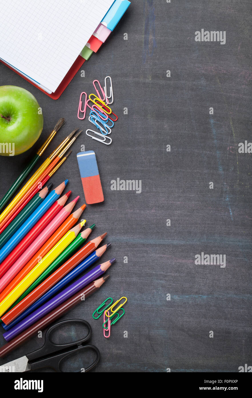 Scuola e forniture per ufficio su lavagna sfondo. Vista da sopra con lo spazio di copia Foto Stock