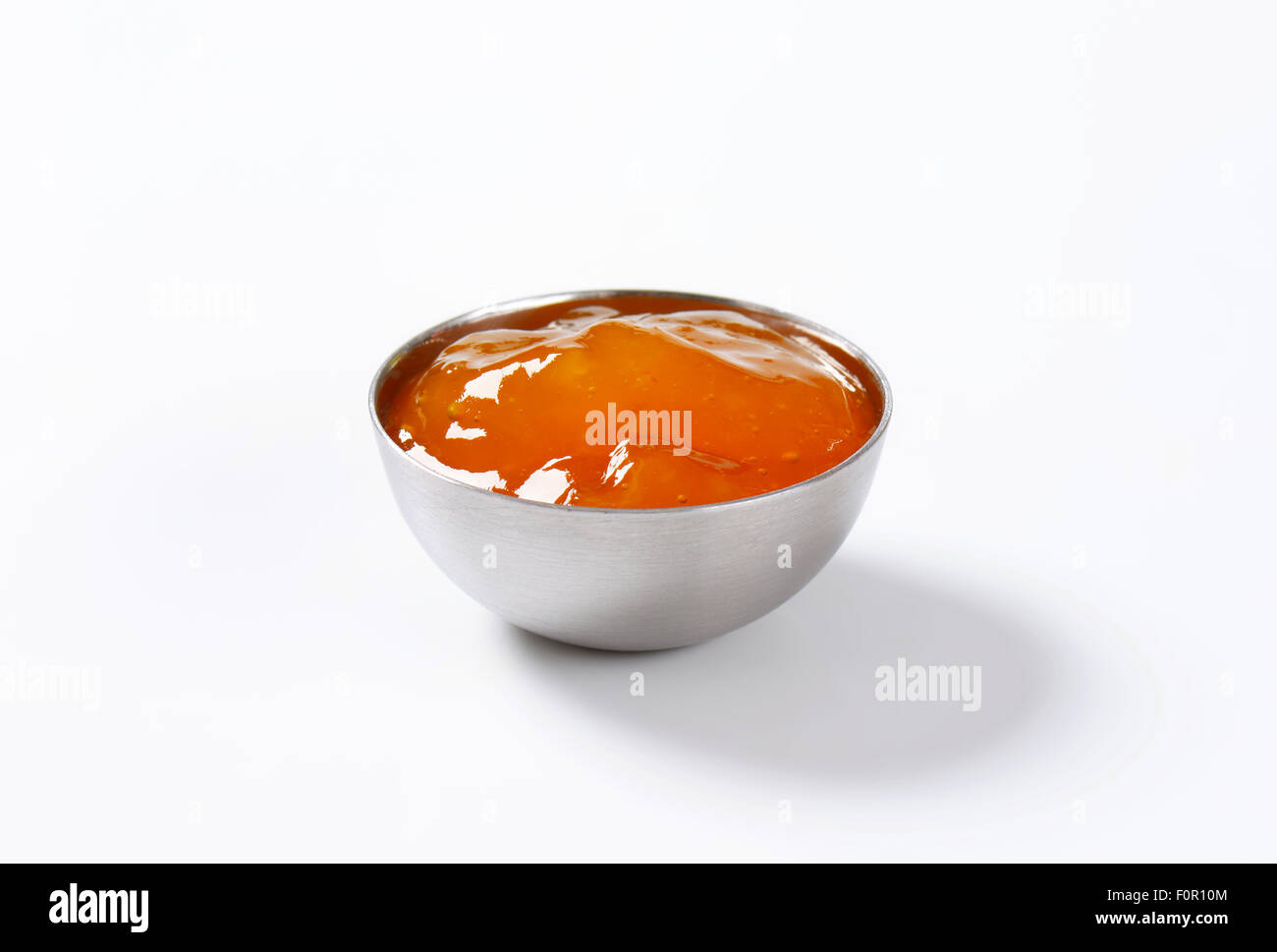 Tazza di confettura di albicocche su sfondo bianco Foto Stock