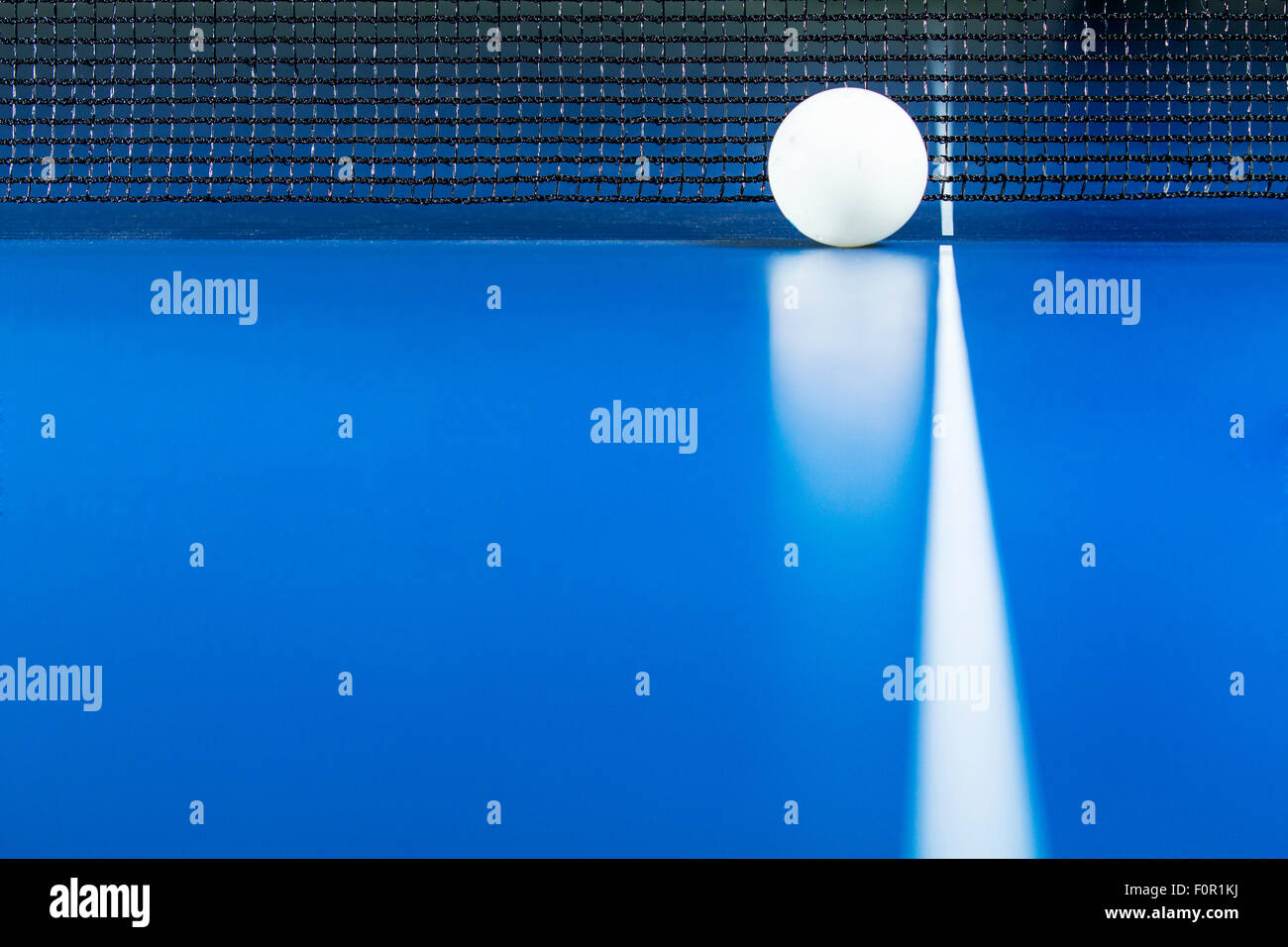 Ping pong palla viene visualizzato accanto al prezzo netto su blu tavolo da ping pong. Foto Stock