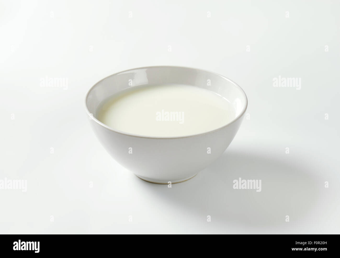 Ciotola di latte su sfondo bianco Foto Stock