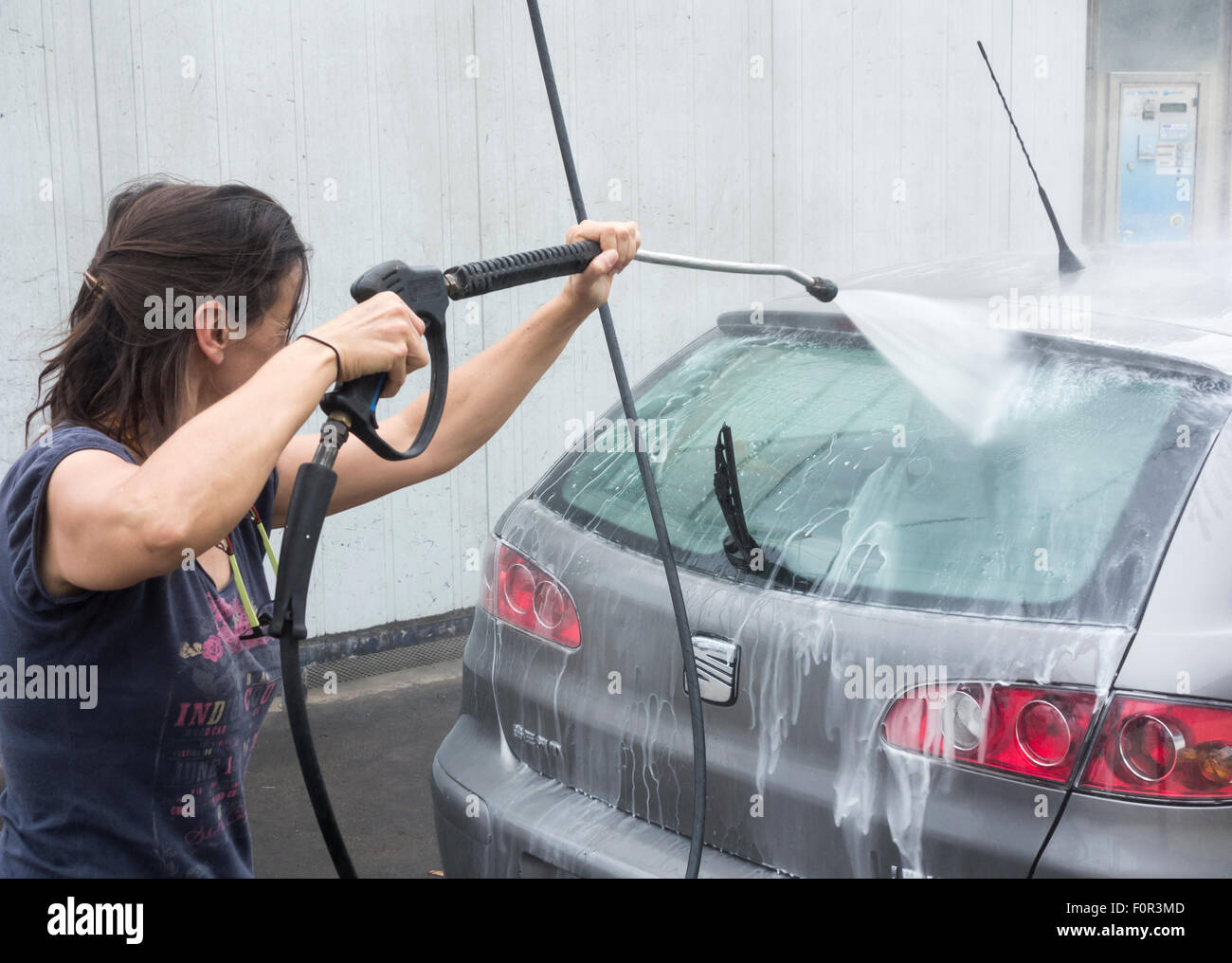 Donna auto lavaggio con idropulitrice Foto stock - Alamy