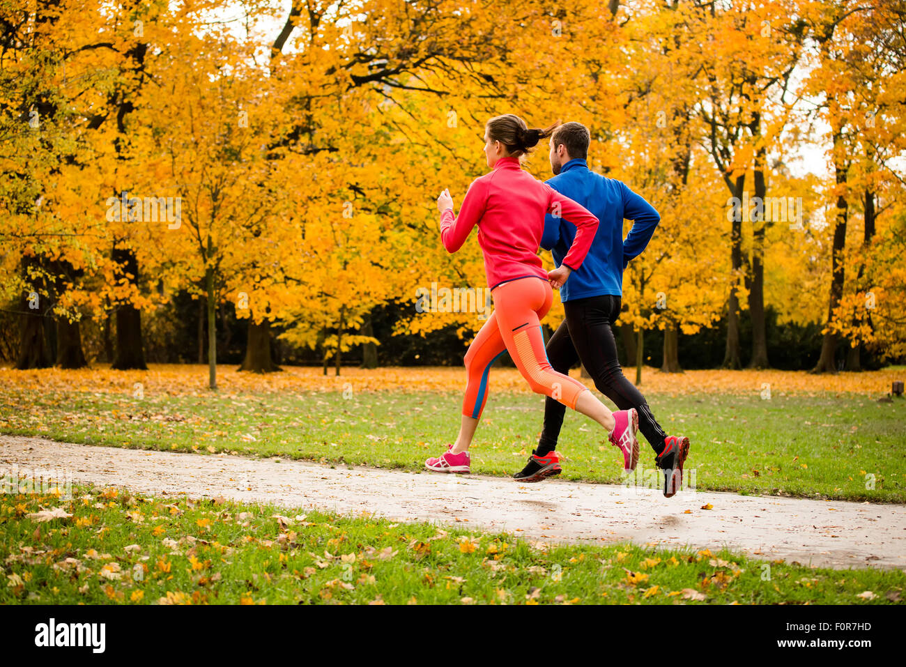 Coppia giovane jogging insieme nel parco - stagione autunnale Foto Stock