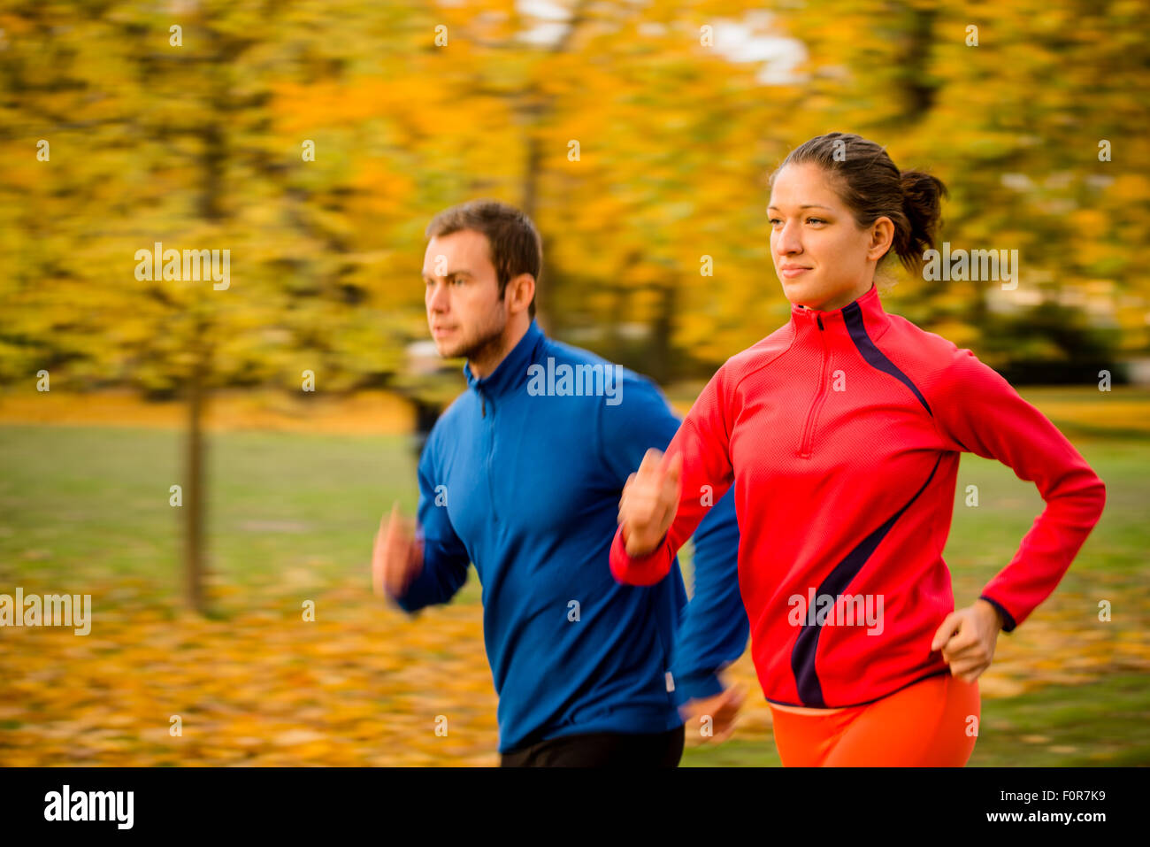 Il panning foto di coppia giovane jogging insieme in natura Foto Stock