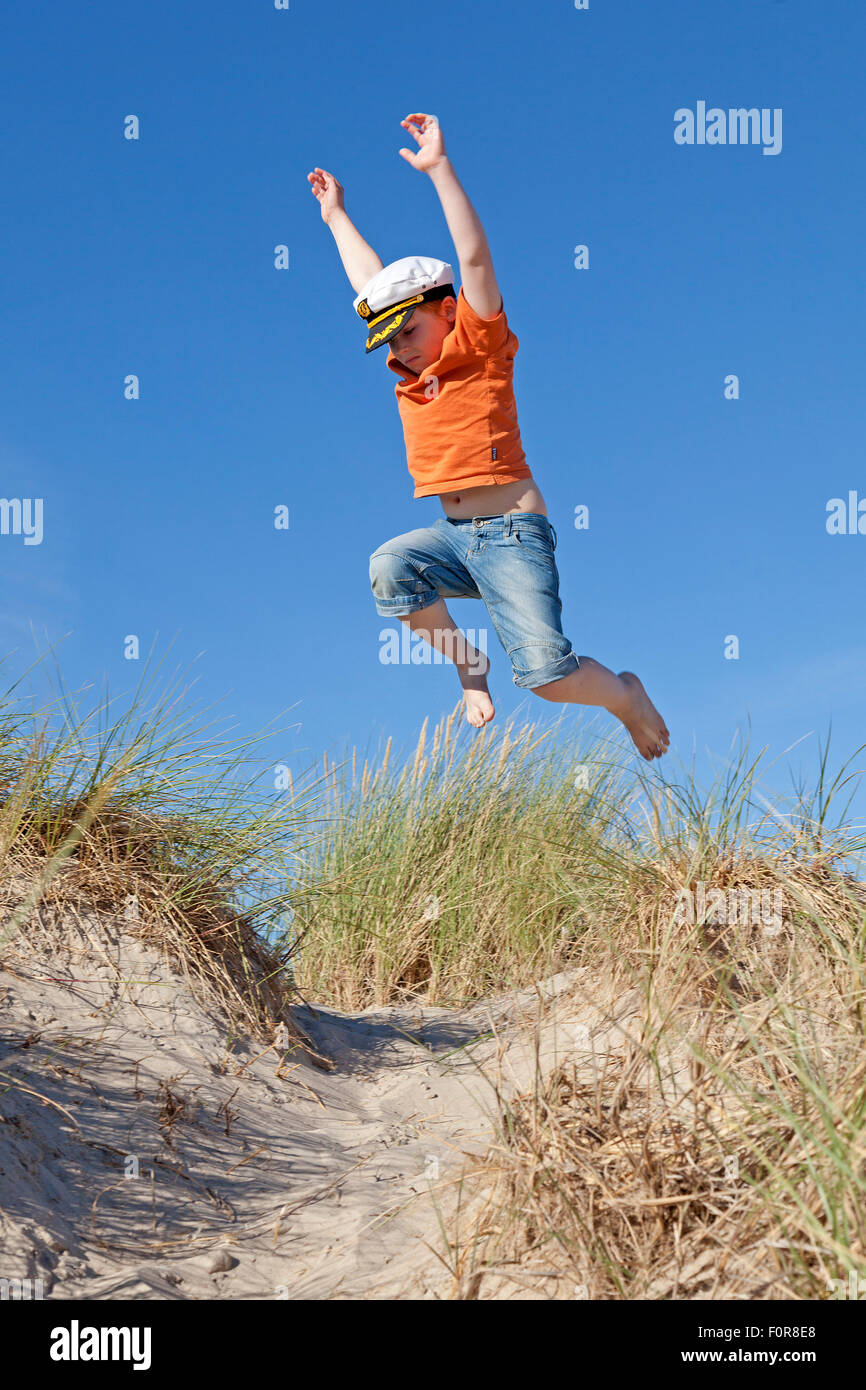 Giovane ragazzo saltare le dune, Warnemuende, Rostock, Meclemburgo-Pomerania Occidentale, Germania Foto Stock