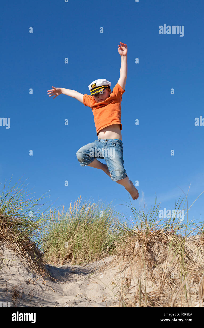 Giovane ragazzo saltare le dune, Warnemuende, Rostock, Meclemburgo-Pomerania Occidentale, Germania Foto Stock
