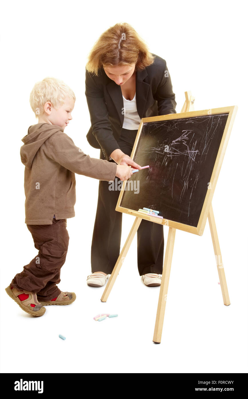 Ragazzo disegno su una lavagna e docente aiutare Foto Stock